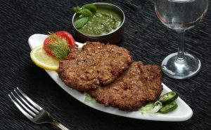 Chapli,Kabab,With,Sauce,Oval,Shape,White,Plate,Black,Background