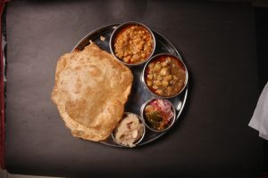 The,Thali,Includes,Hot,,Fluffy,Purideep fried,Breadserved,Alongside,Warm,,Sweet